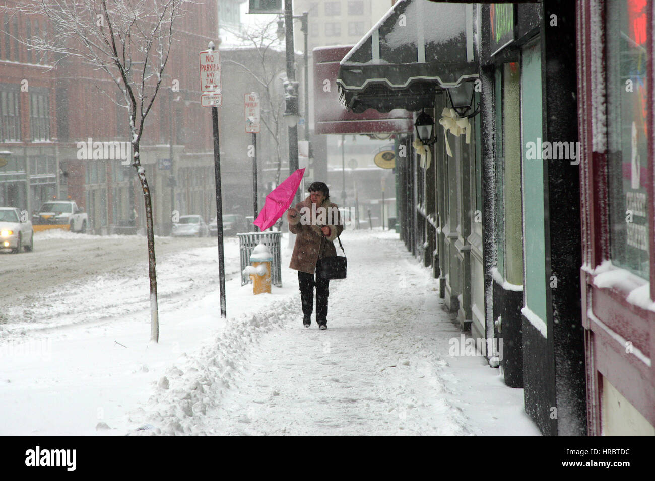 Snowstorm downtown Portland Maine woman walking sidewalk winter storm snow New England USA