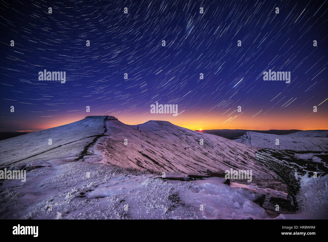 Star trails above a snow covered Pen y Fan in the Brecon Beacons Stock Photo