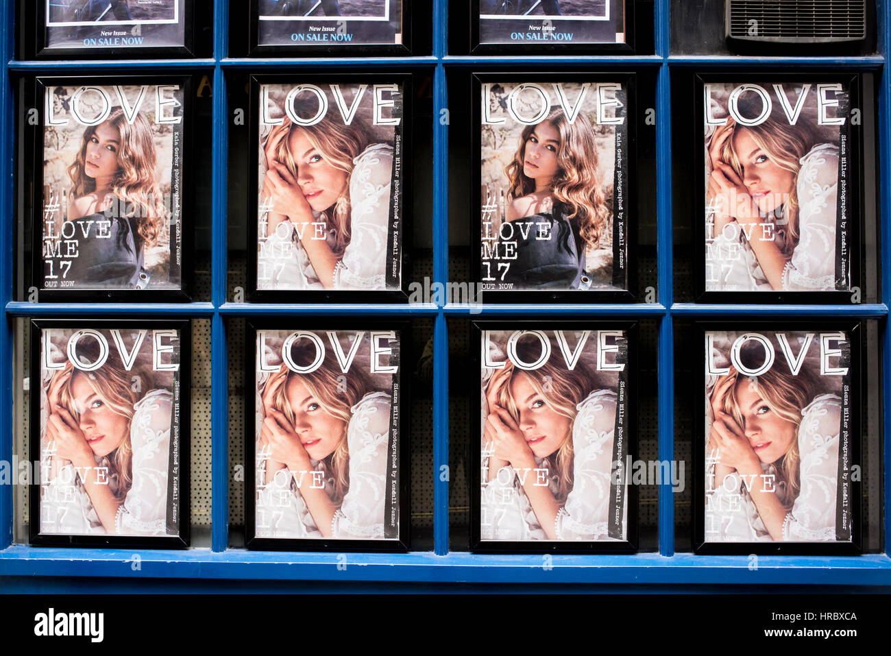 Love magazine covers on a shop window. Sienna Miller and Kaia Gerber were photographed by Kendall Jenner. Love is a bi-annual British style magazine f Stock Photo