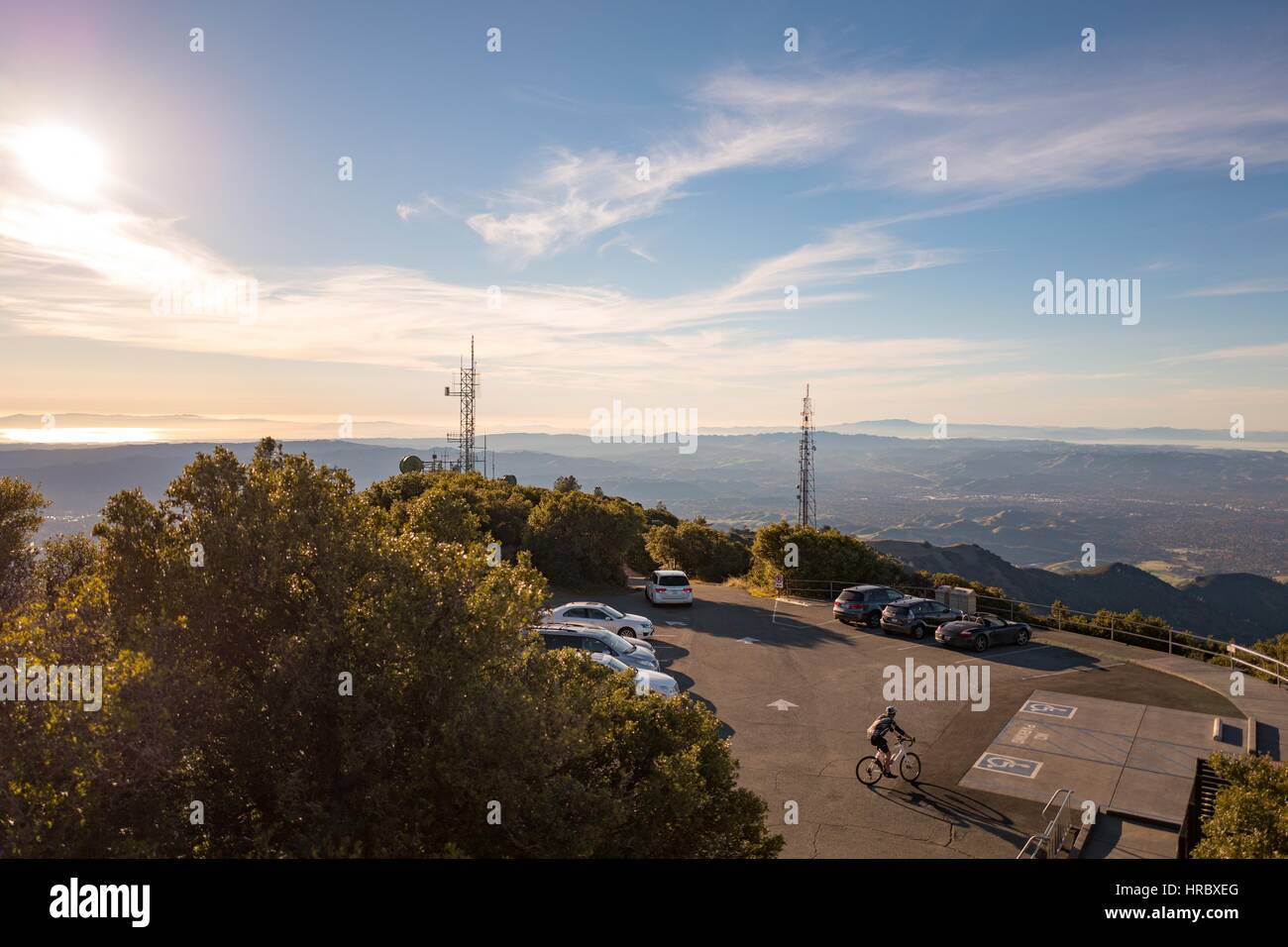 A biker cycles through a parking lot at the summit of Mount Diablo at dusk, in Walnut Creek, California, December 3, 2016. As the tallest peak in the San Francisco Bay Area, Mount Diablo is a popular destination for adventurous road cyclists. Stock Photo