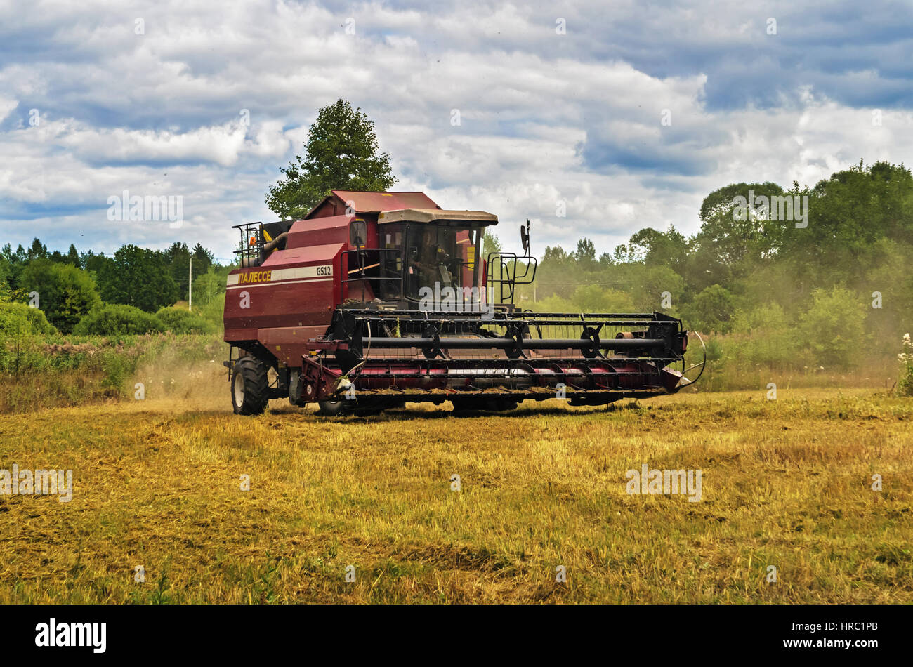 Cleaning agricultural field by harvester Stock Photo Alamy