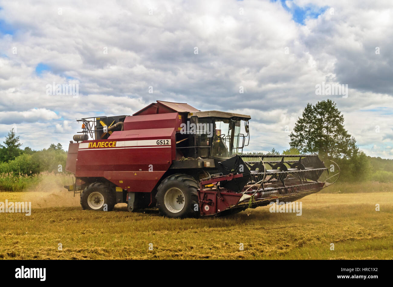Cleaning agricultural field by harvester Stock Photo Alamy