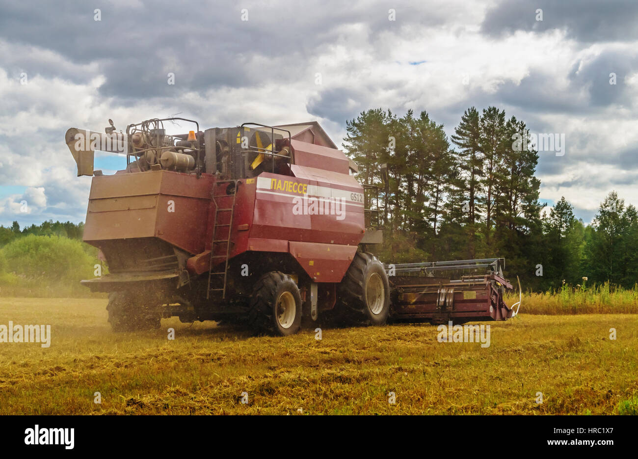 Cleaning agricultural field by harvester Stock Photo Alamy