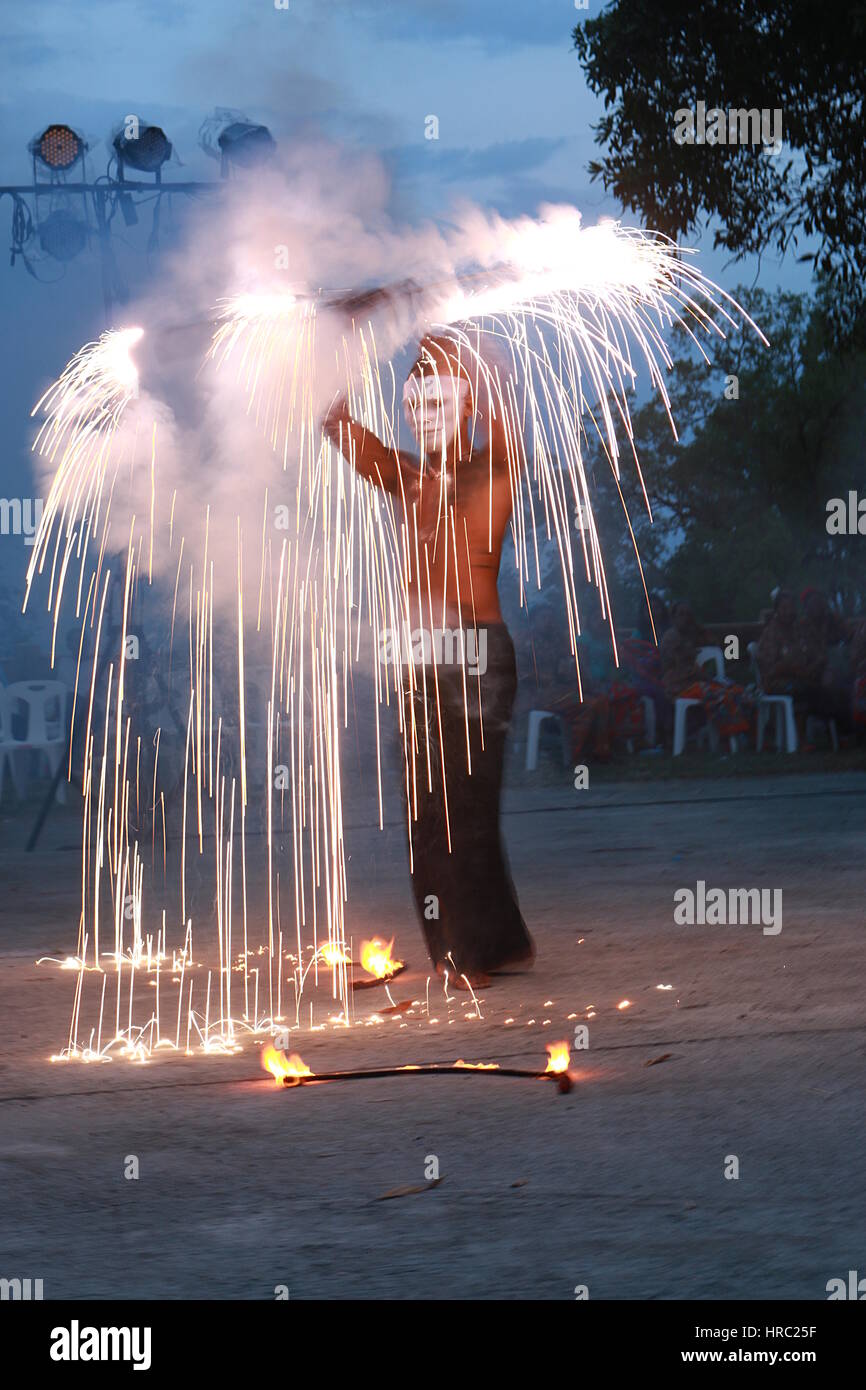 Fire dancer using petrol/gasoline (yellow flames) and fireworks (white sparks) Stock Photo
