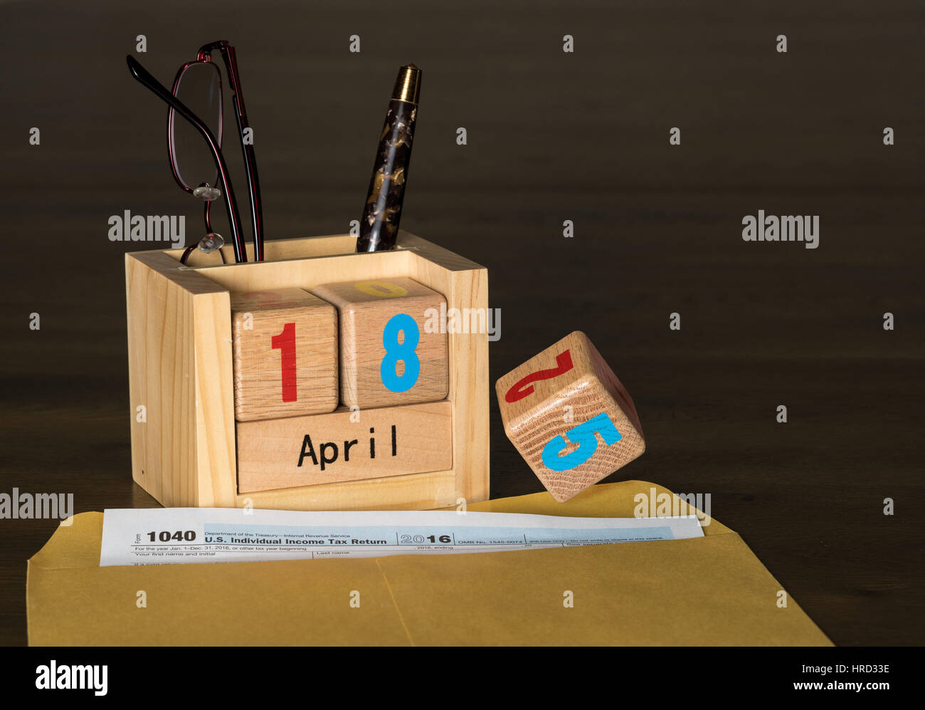 Wooden letters in calendar with Form 1040 income tax for 2016 showing tax day for filing is April 18 2017 instead of the normal 15th. Number 5 is show Stock Photo