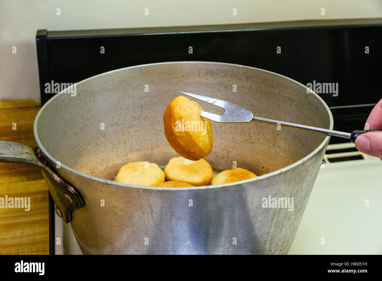 Donuts frying in deep fat. Preparation of traditional donuts Stock