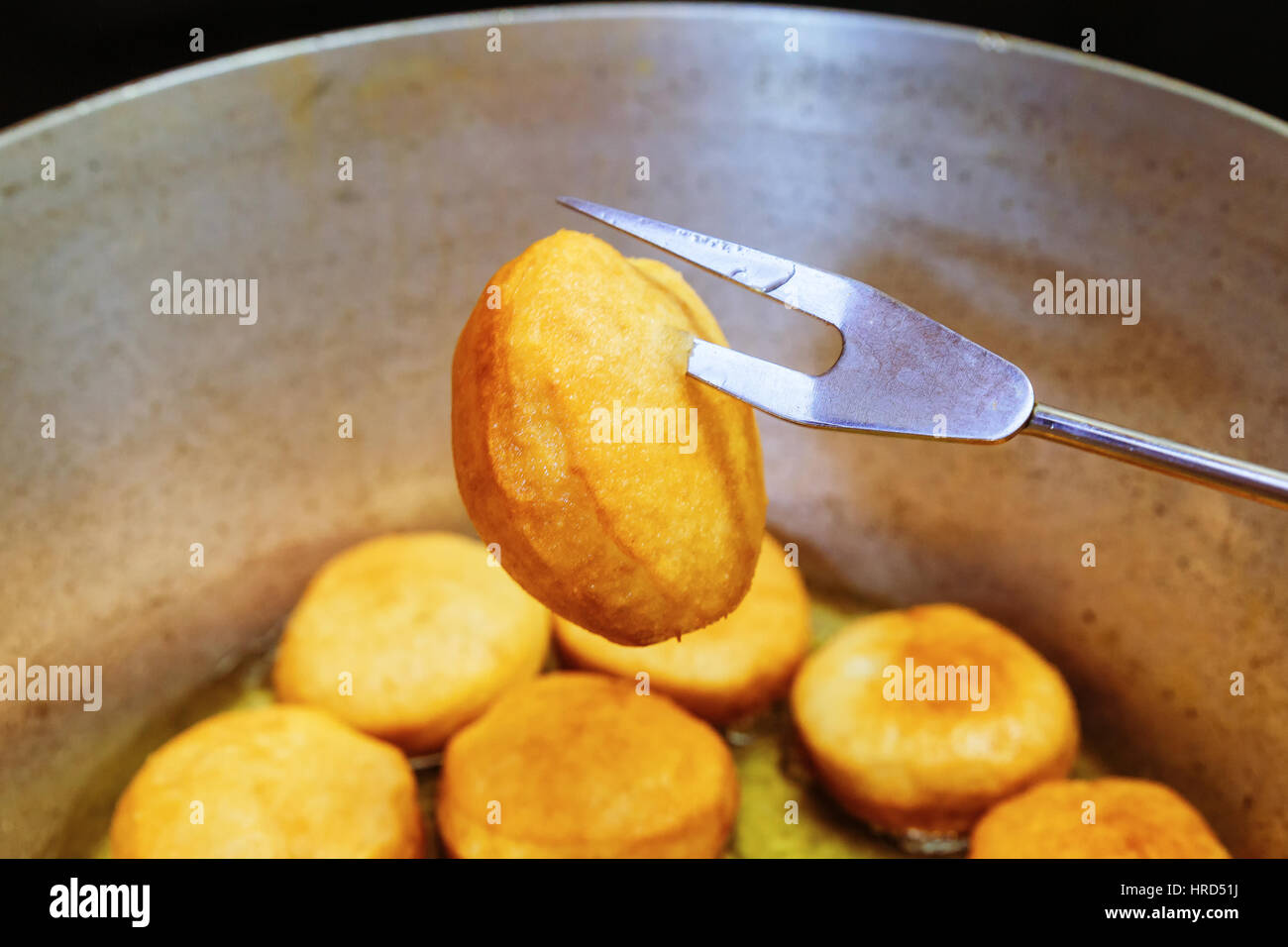Donuts frying in deep fat. Preparation of traditional donuts Stock