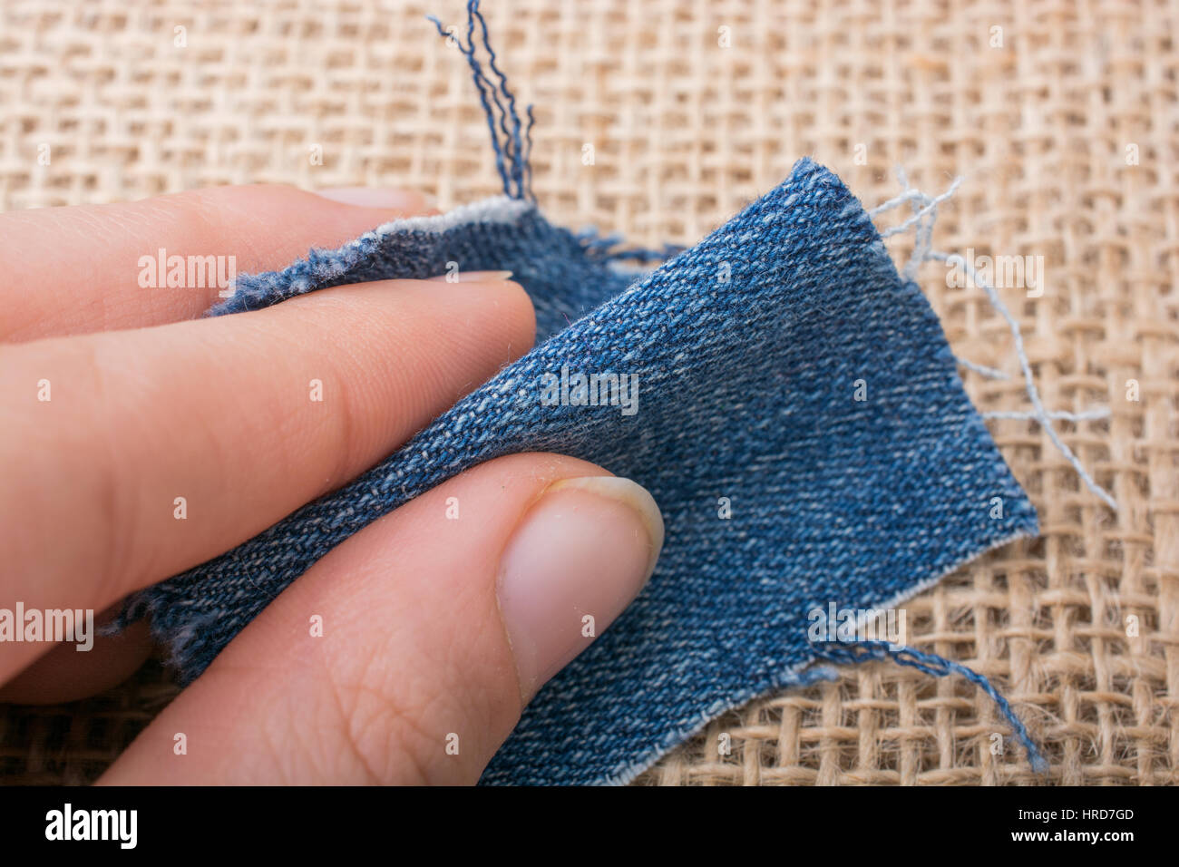 Denim canvas in hand placed on linen canvas as a background Stock Photo