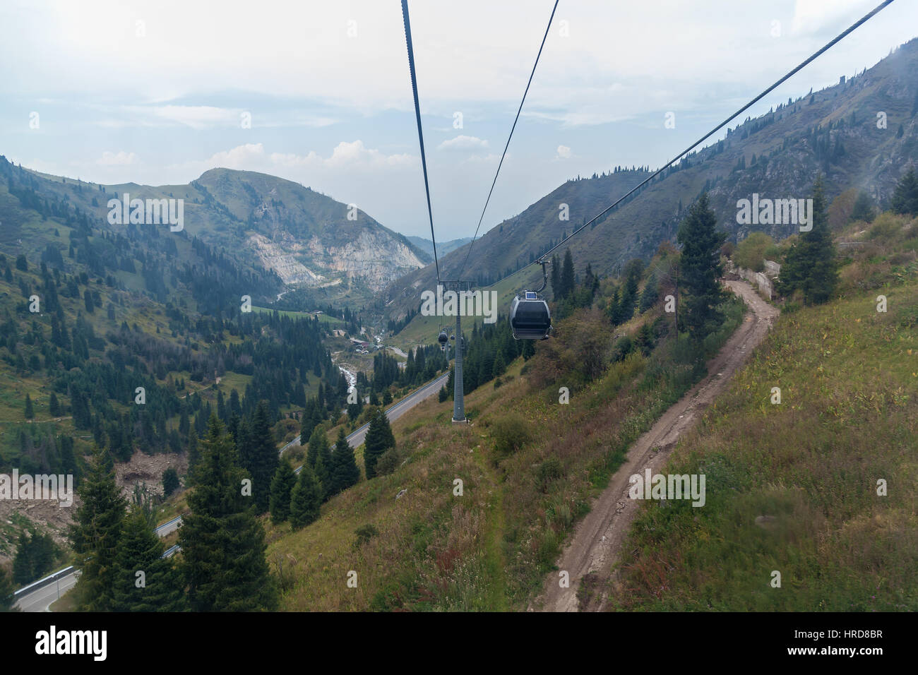 Cableway among the mountains. Cableway with cabins moving through the Kazakhstan mountains in summer. Stock Photo