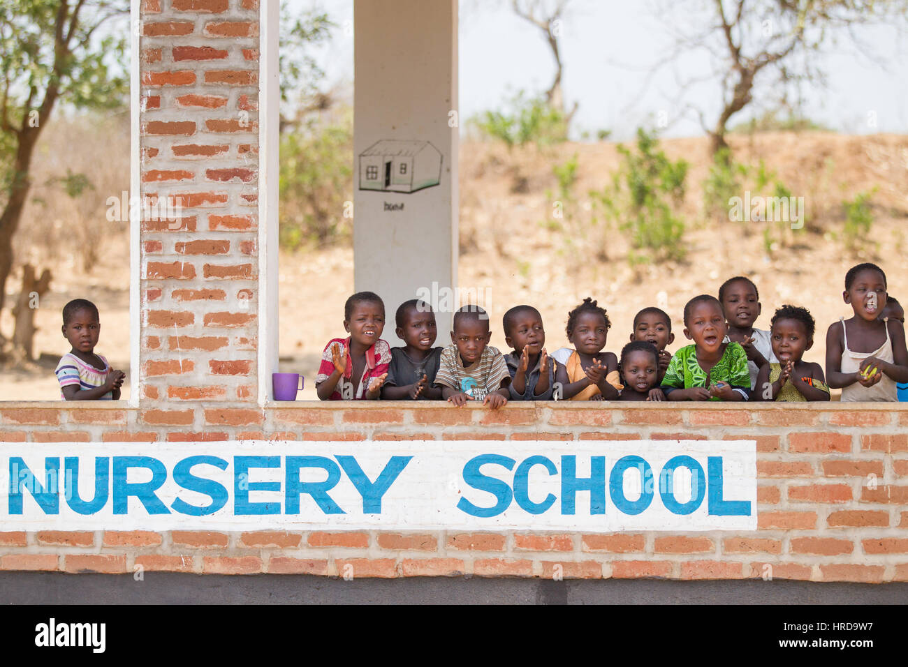 Young Malawian children go to school in a building donated by projects from the local wildlife reserve, Majete. The rural village borders the park. Stock Photo