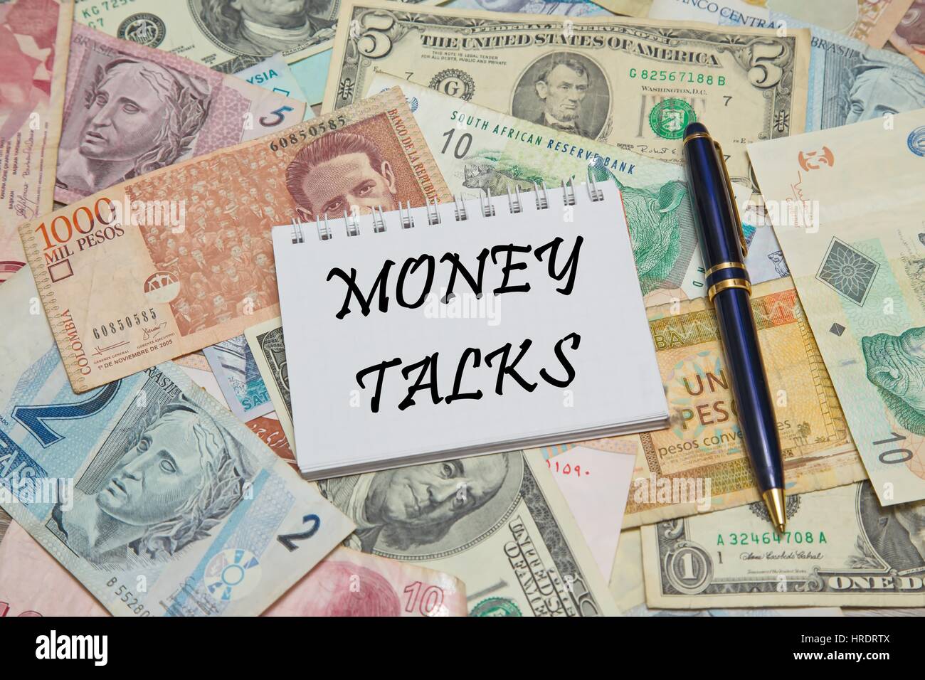 Notebook page with MESSAGE, background from different world Currencies Stock Photo