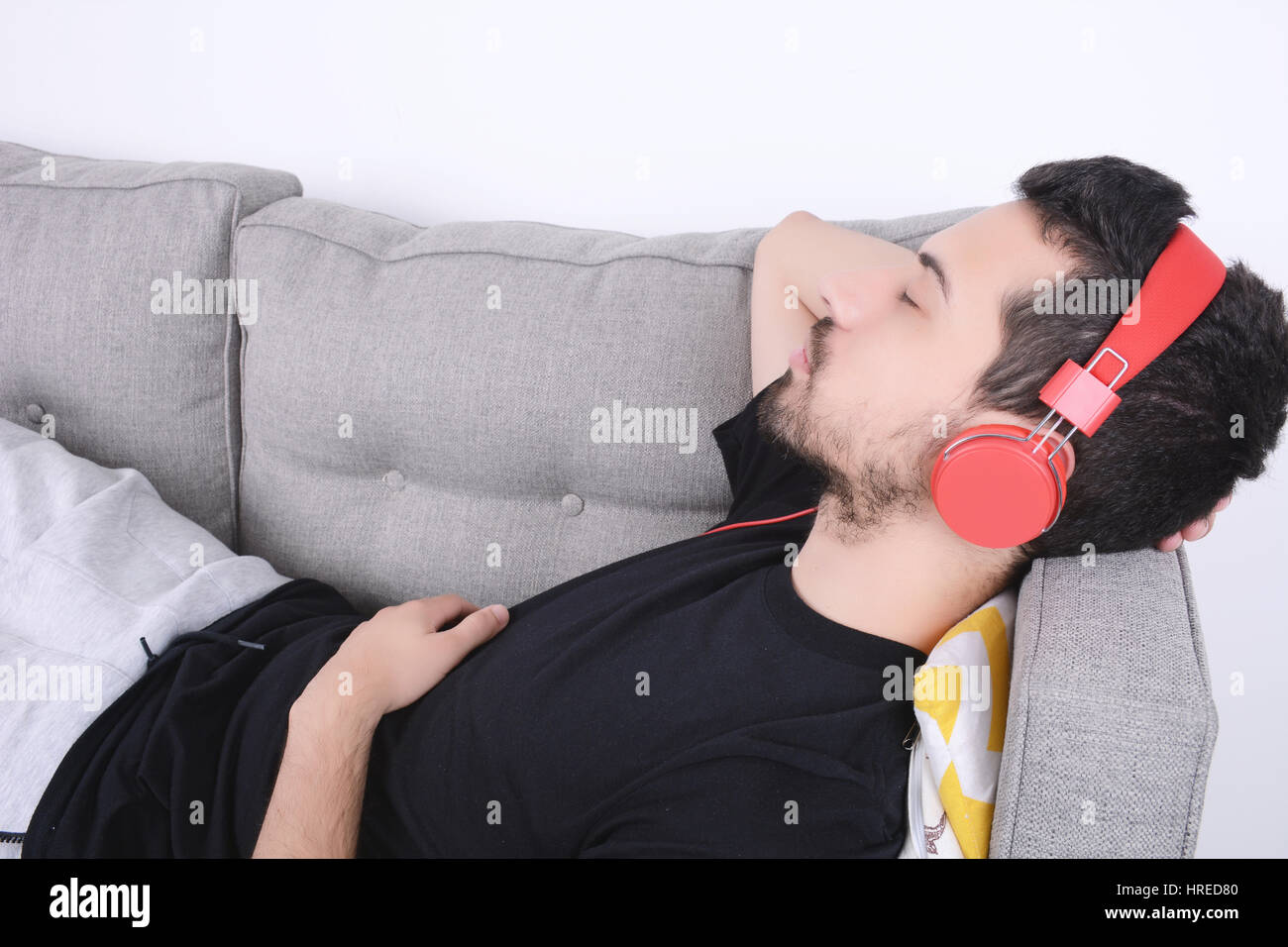 Attractive young man listening to music with headphones and relaxed on ...