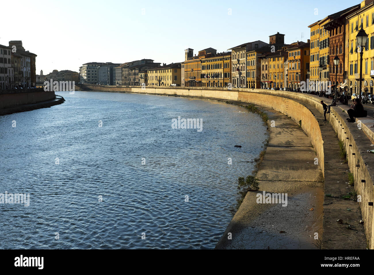 Urban landscape at golden hour before sunset - Arno river bend view from Ponte di Mezzo, Pisa, Tuscany, Italy, Europe - Beautiful warm natural light Stock Photo