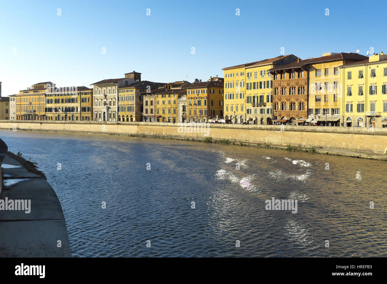 Urban landscape at golden hour before sunset - Arno river bend view from Ponte di Mezzo, Pisa, Tuscany, Italy, Europe - Beautiful warm natural light Stock Photo