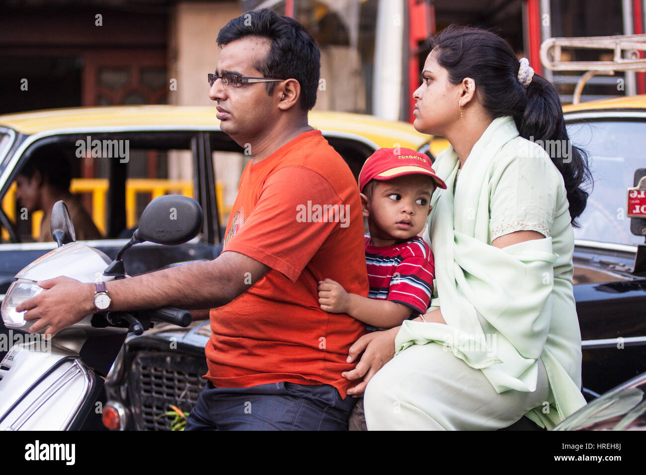 Family,on,scooter,motorbike,in,traffic,without,helmet,helmets,pollution,vehicle,fumes,no,mask,masks,health,safe,Mumbai,Bombay,India,Indian,Asia,Asian, Stock Photo