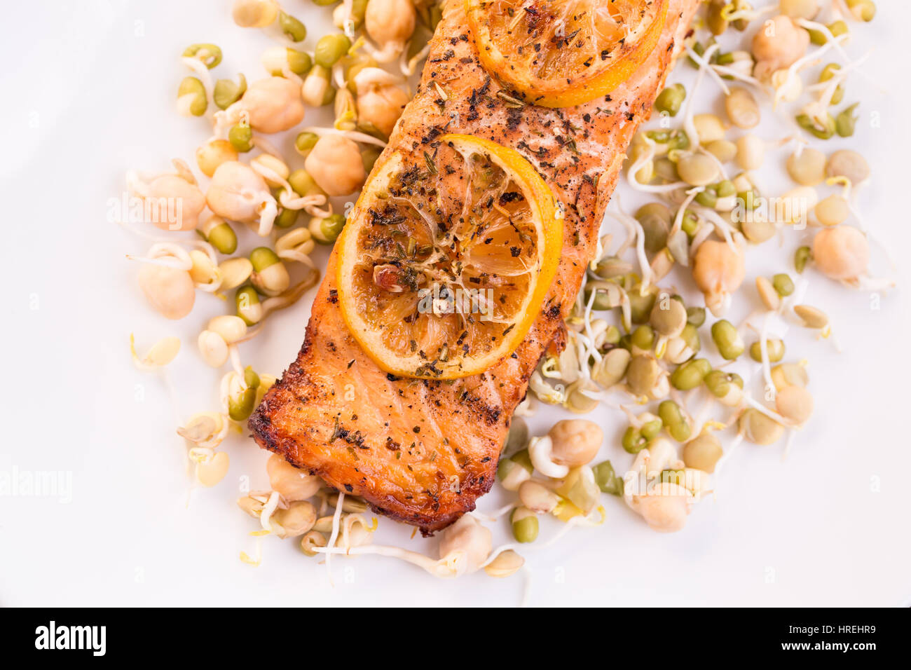Grilled salmon fillet with lemon and sprouts on white plate Stock Photo ...
