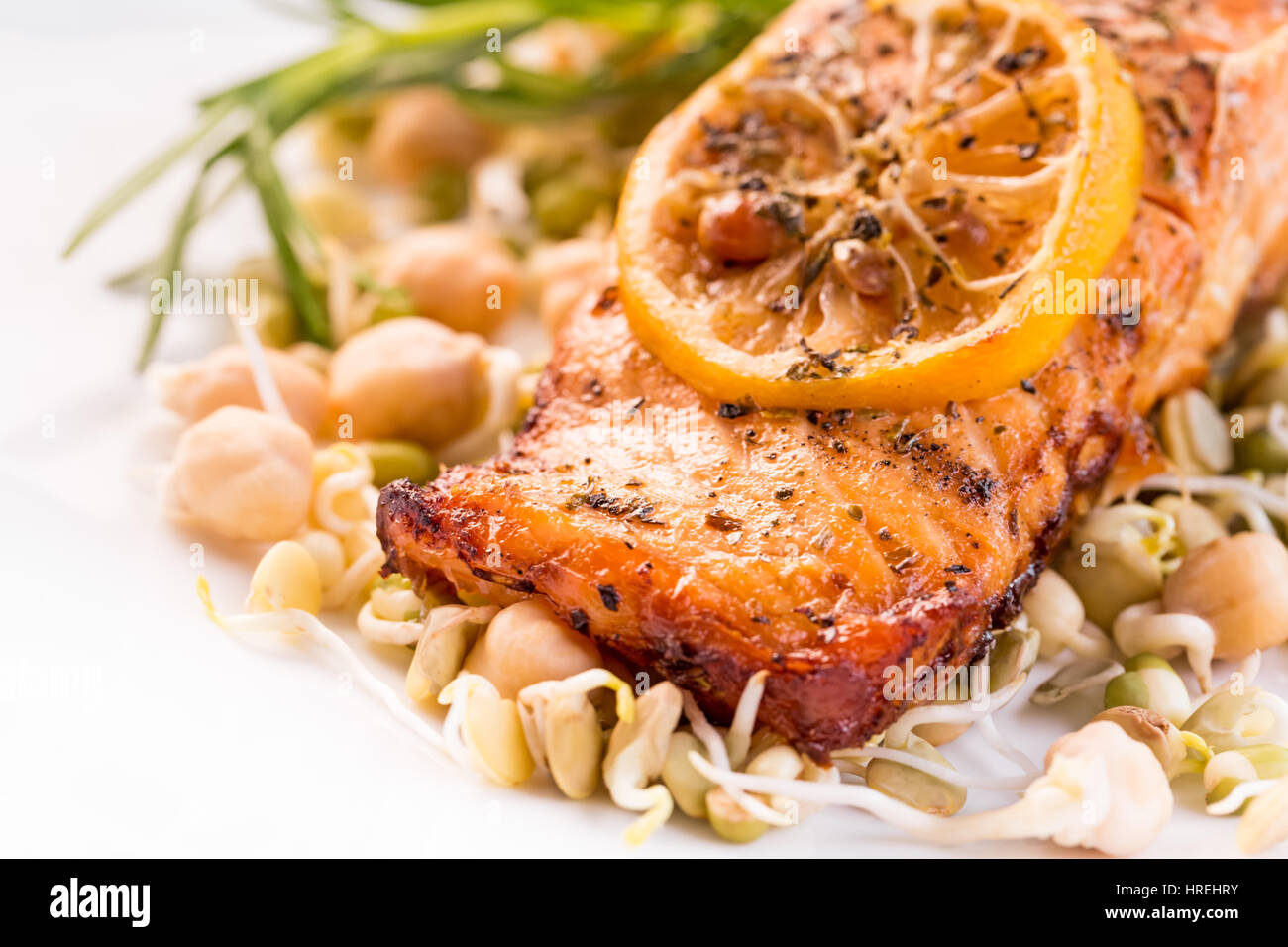 Grilled salmon fillet with lemon and sprouts on white plate Stock Photo ...