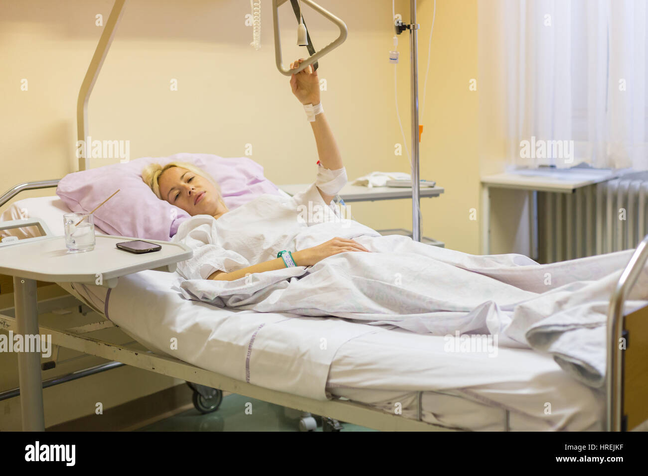 Bedridden female patient lying in hospital bed, recovering after