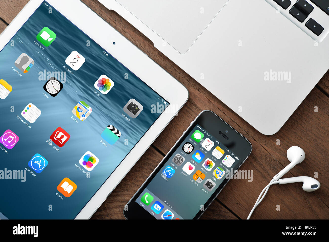 KIEV, UKRAINE - JANUARY 29, 2015: Apple iPhone 5s, iPad Air 2 and MacBook Air on table. Apple Inc. is an American multinational corporation that desig Stock Photo