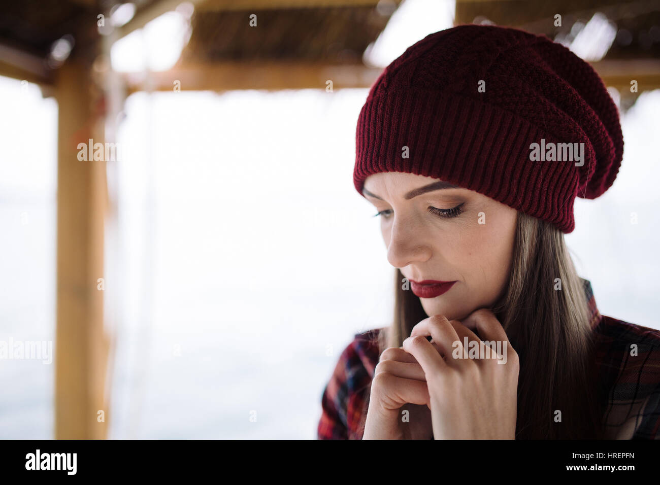 sad young woman in burgundy hat Stock Photo