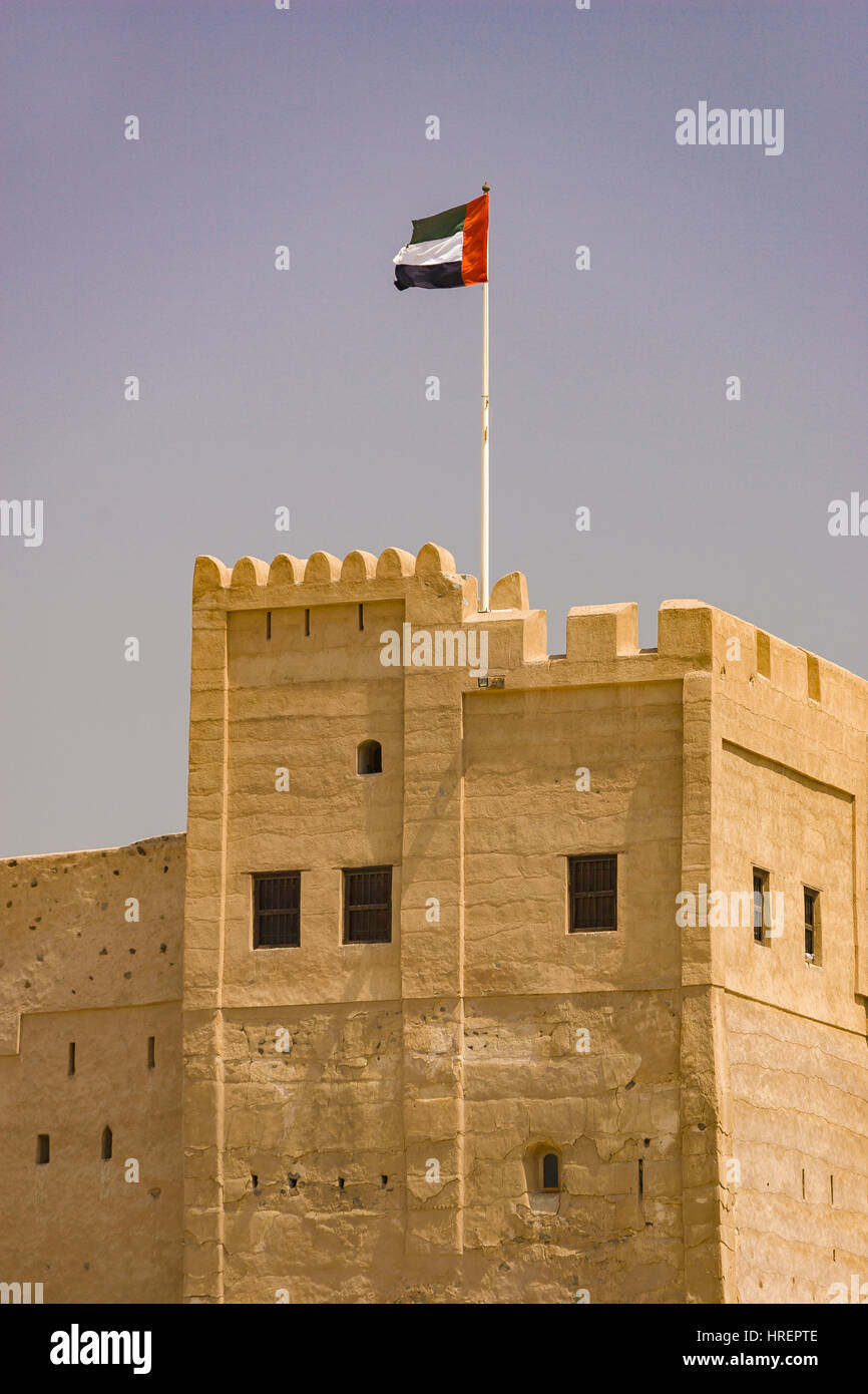 FUJAIRAH, UNITED ARAB EMIRATES - UAE flag flying over 360-year-old Fujairah Fort. Stock Photo