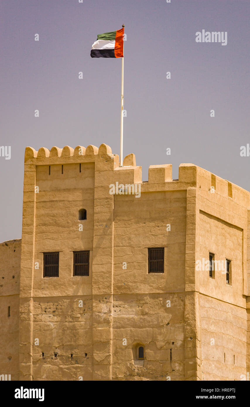 FUJAIRAH, UNITED ARAB EMIRATES - UAE flag flying over 360-year-old Fujairah Fort. Stock Photo