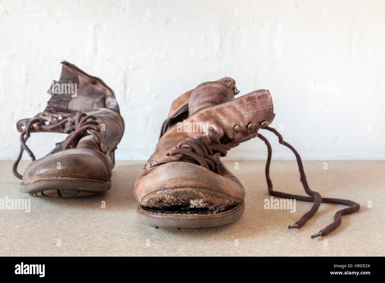 Pair of worn out old boots, one boot with the sole coming off Stock Photo