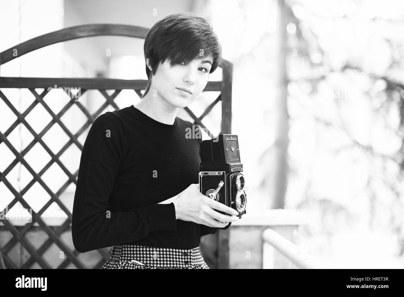 Rome, Italy. february 26 2017. Young pretty woman posing with a vintage Rolleiflex camera, black and white Stock Photo