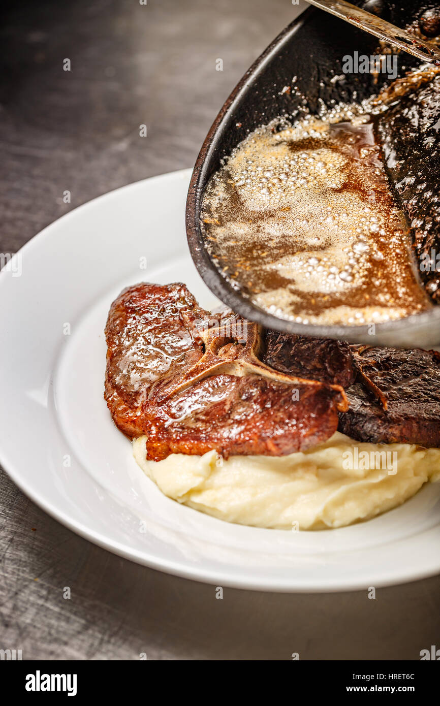 Chef pouring gravy sauce on wild boar steak Stock Photo Alamy