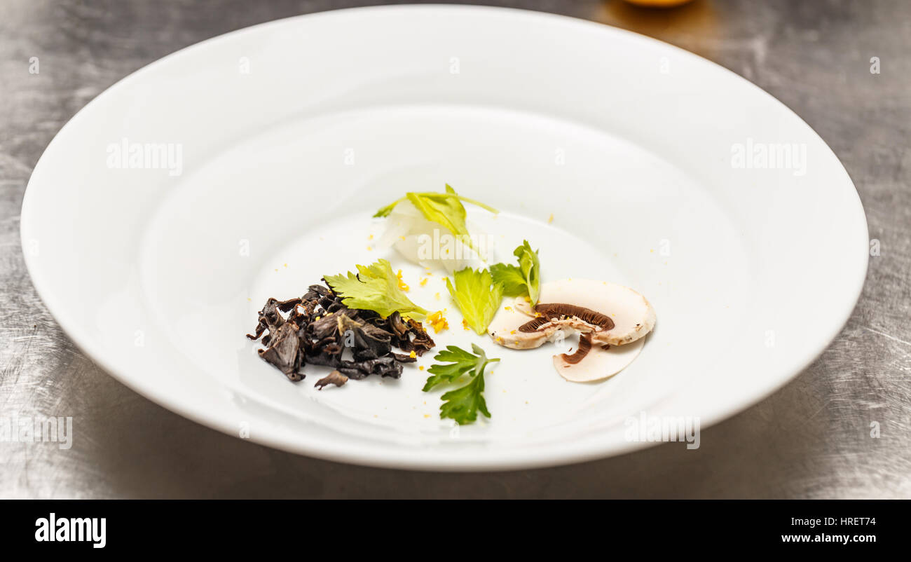 Soup plate arranged for soup with champignon and black trumpet mushroom Stock Photo