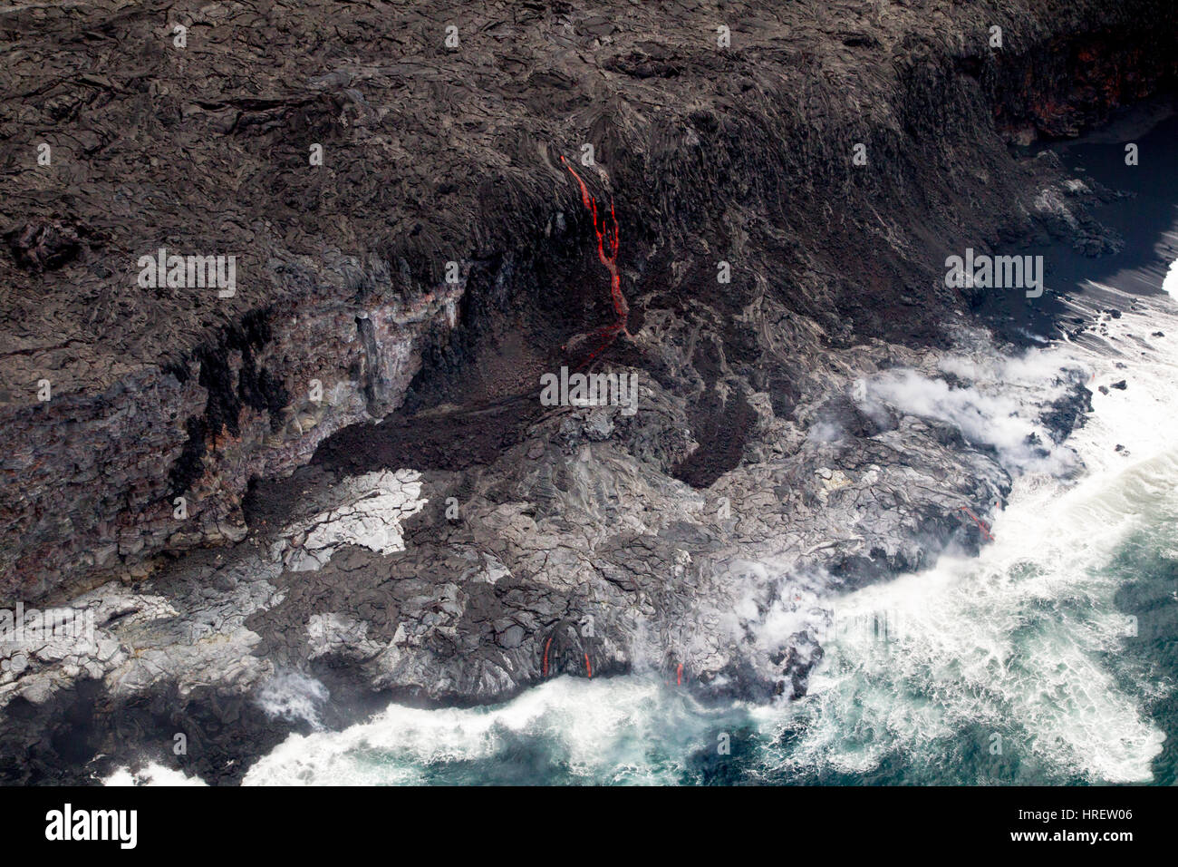 Aerial shot of red glowing lava flowing into the sea on the south coast of Big Island, Hawaii, USA. Stock Photo