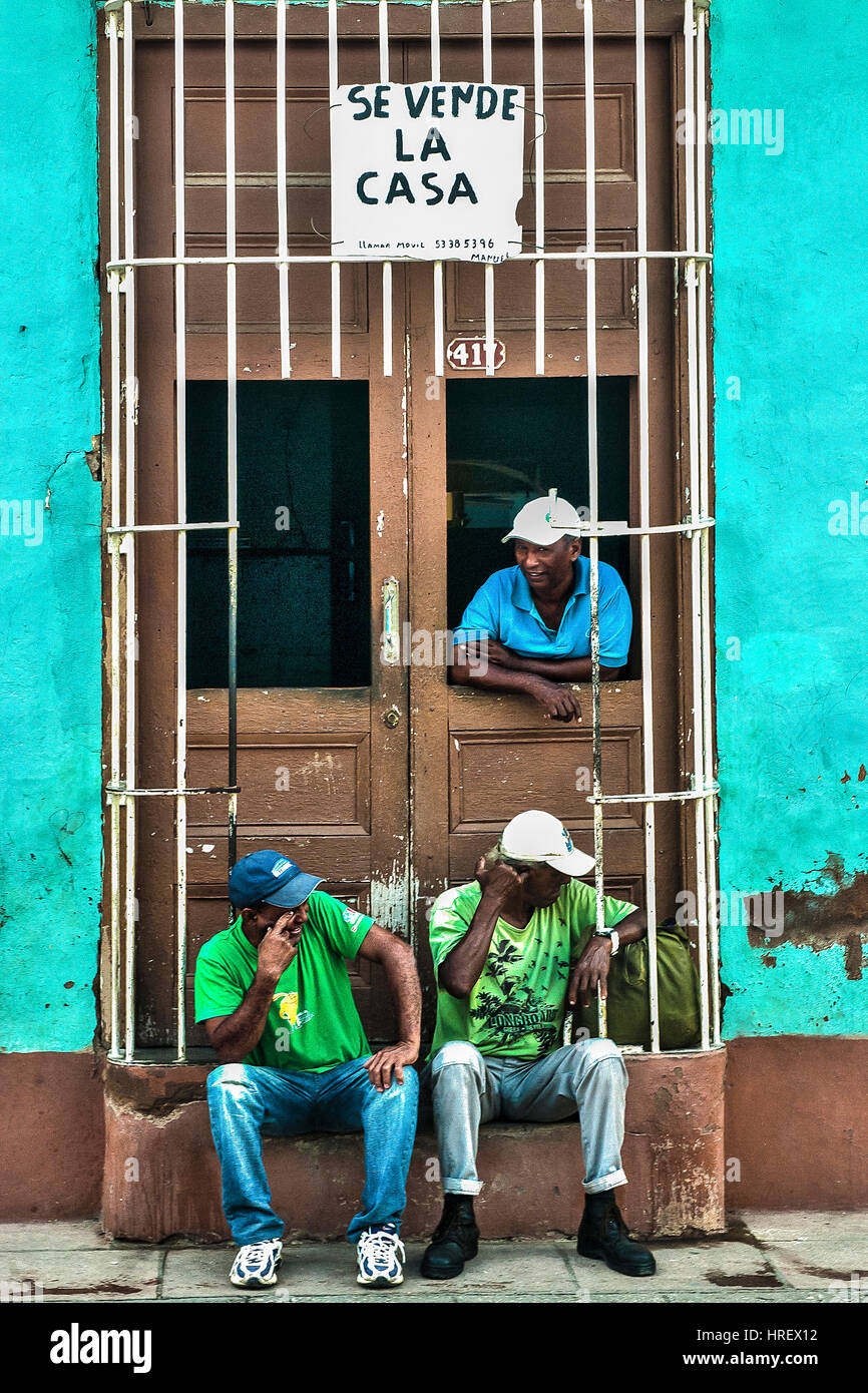 A group of men in front of their house on sale, in Trinidad, Cuba Stock