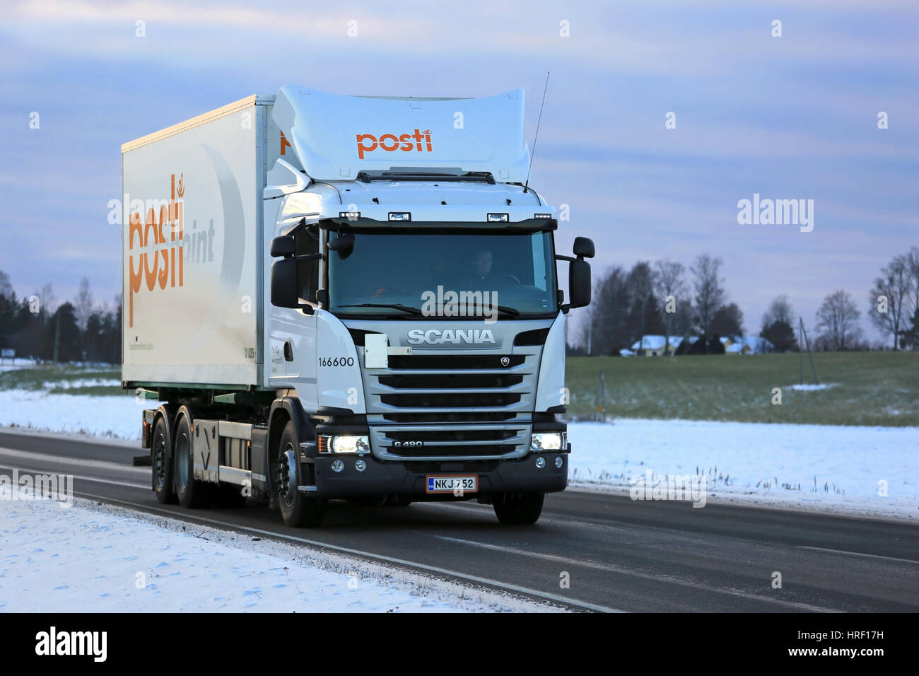 SALO, FINLAND - NOVEMBER 11, 2016: Scania G490 delivery truck of Posti Group, Finnish Post moves along road on a winter evening to collect and transpo Stock Photo