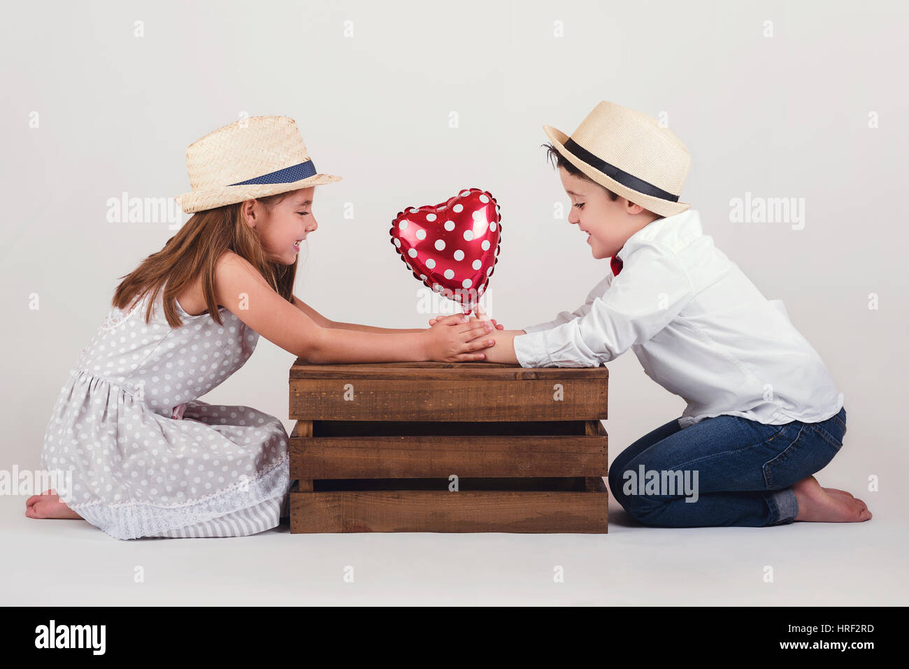 Little boyfriends. Gives a little boy Valentine's heart to girlfriend. Stock Photo