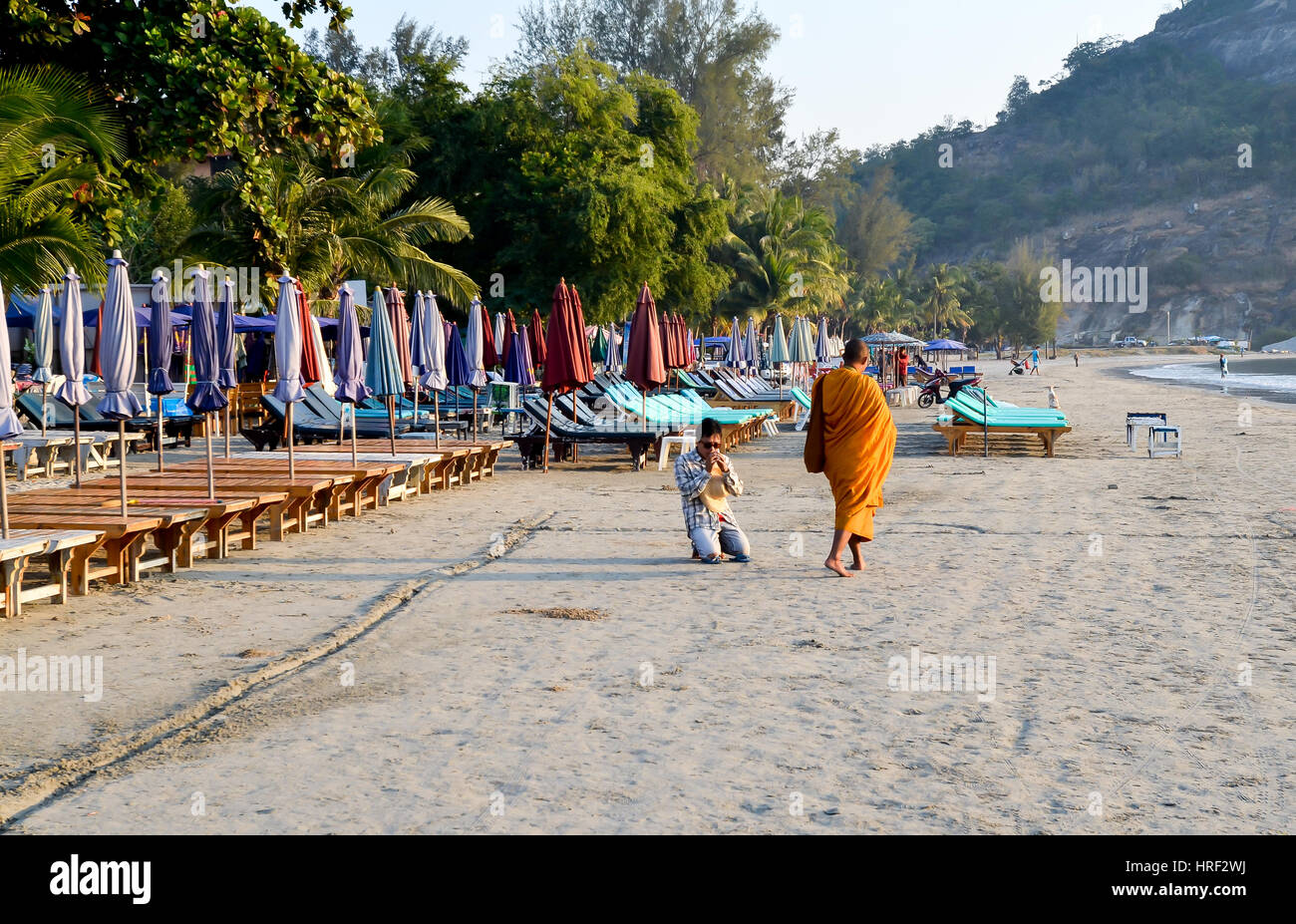 devout buddhist is praying to a monk at the morning beach of hua hin, tahiland Stock Photo