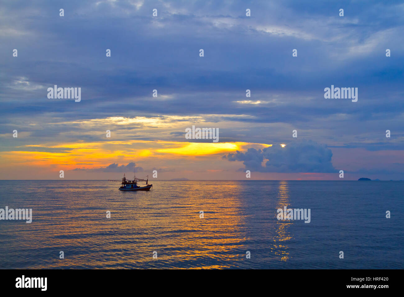 Beautiful sunset with fishing boat Stock Photo - Alamy