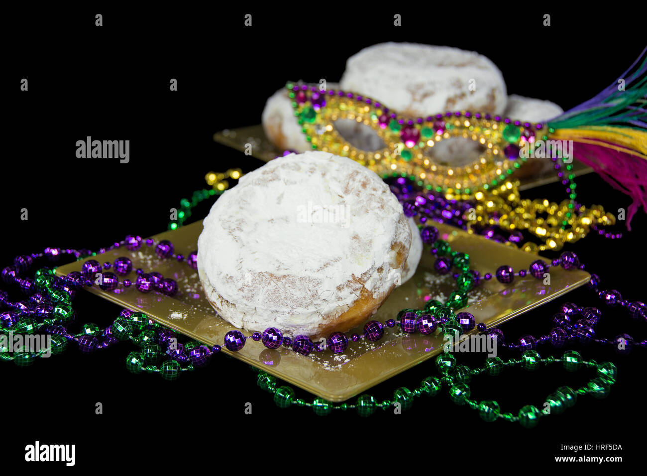 Fat Tuesday paczki with party beads and mask Stock Photo