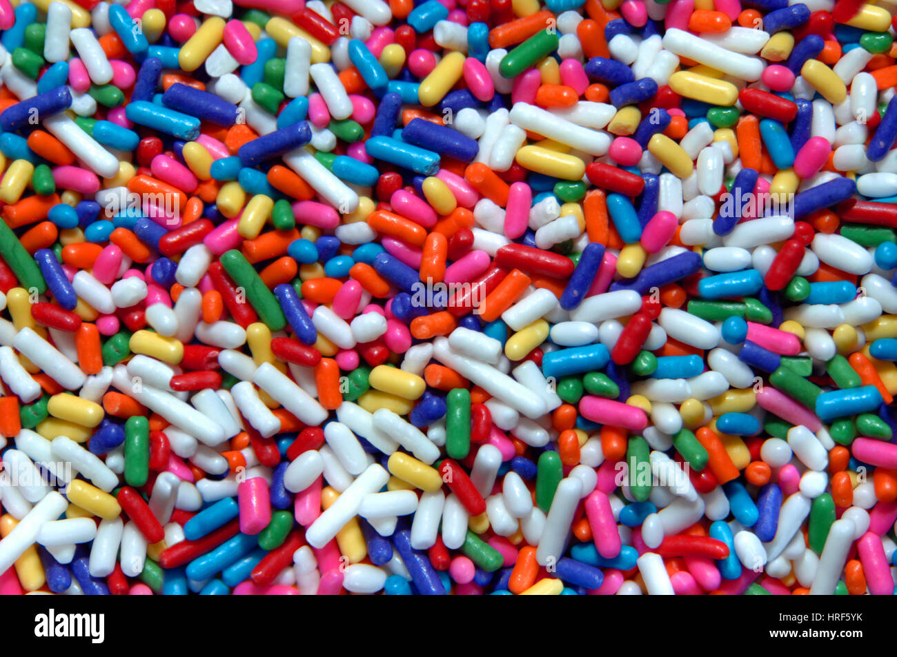 Small, oblong, pieces of multi-colored candy lay in a store ready for sale. Stock Photo