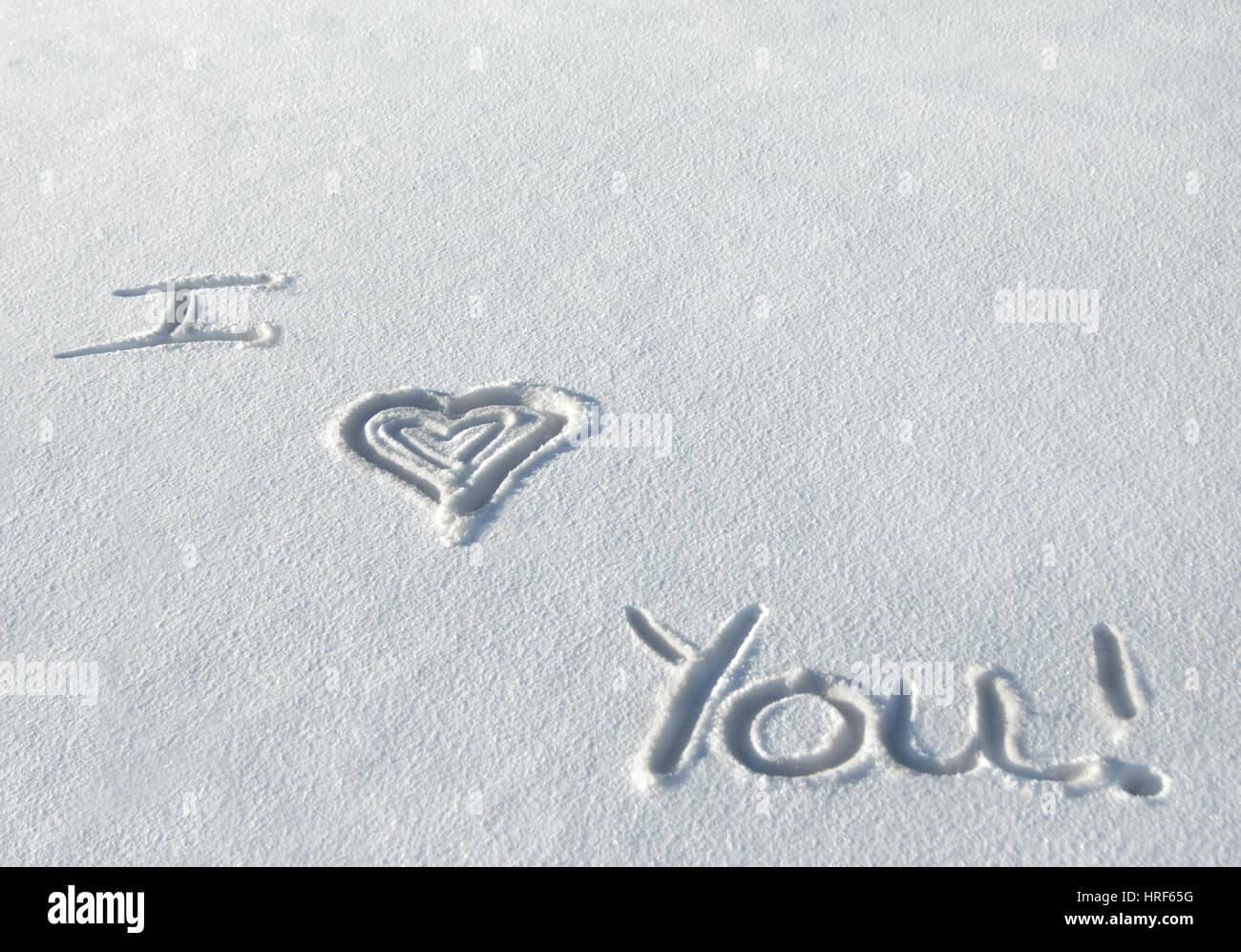 Handwritten message in the snow says 'I love you.'  Message is written in a fresh layer of snow in Colorado. Stock Photo