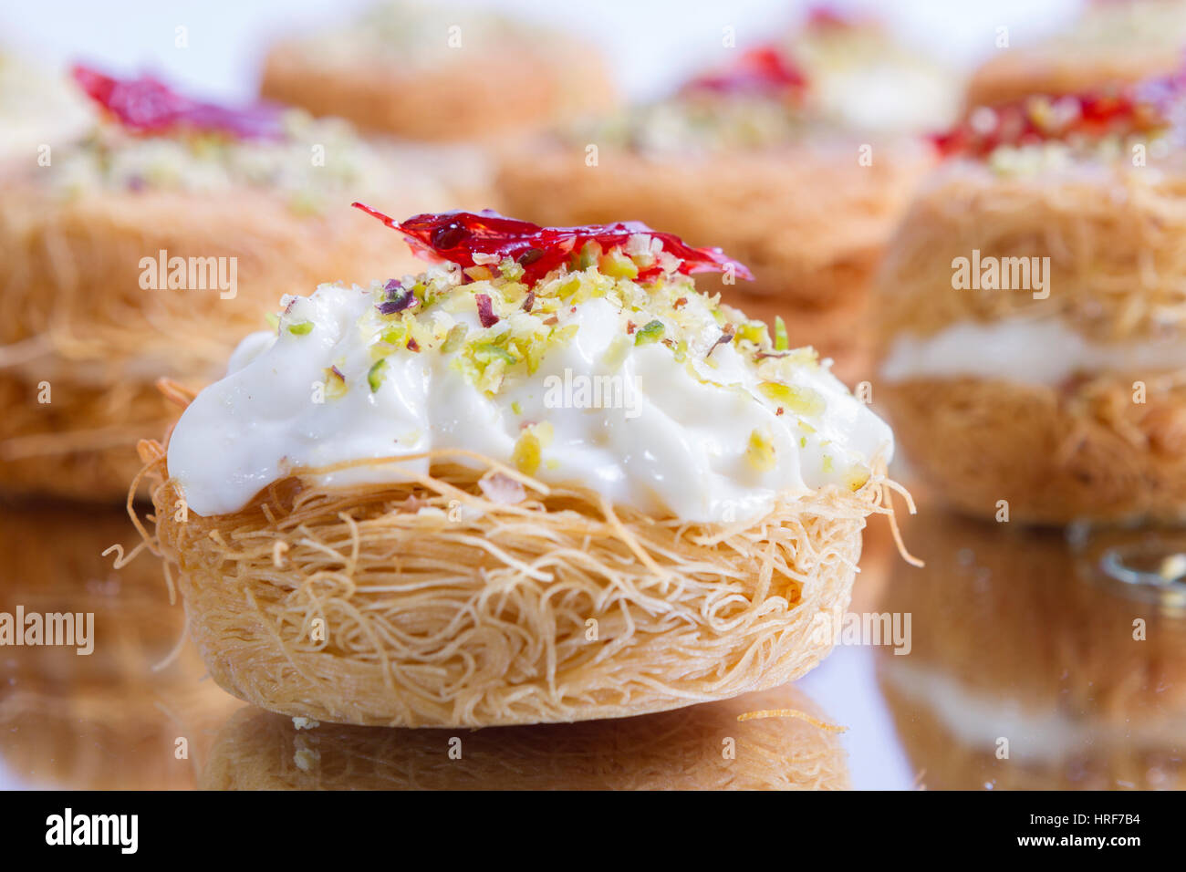 Knafe or Kunafe is a very popular dessert in the levant Lebanon, Syria, Turkey, Jordan. crunchy crust, creamy filling and orange flower jam on the top. Stock Photo