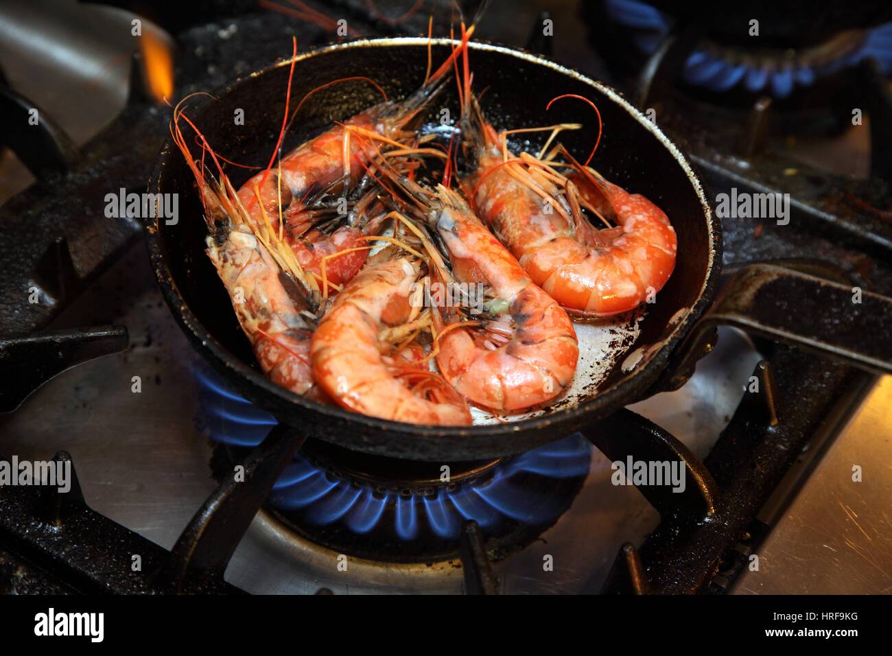 https://c8.alamy.com/comp/HRF9KG/cooking-large-prawns-langoustines-in-a-frying-pan-within-a-commercial-HRF9KG.jpg