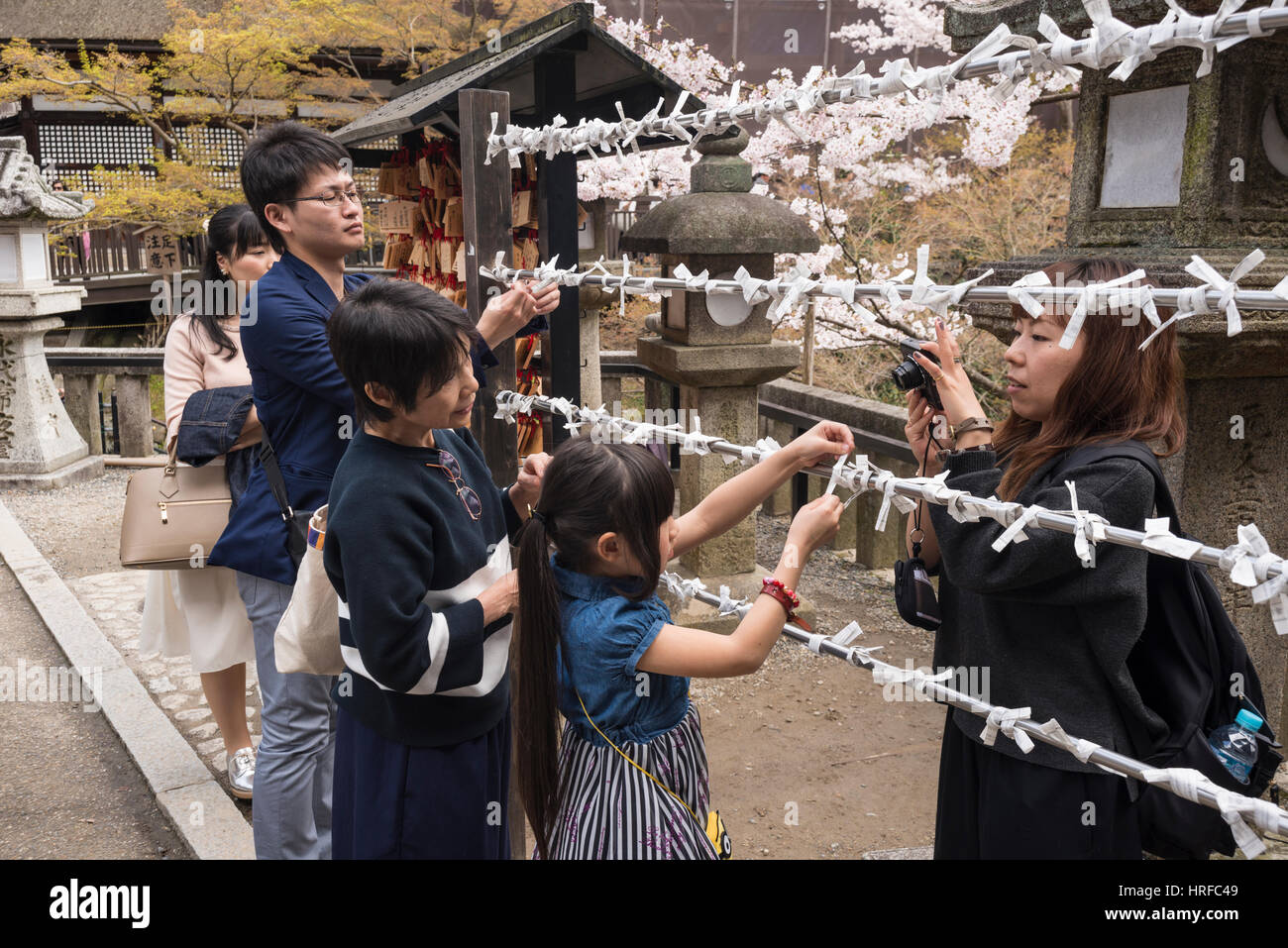 People tying their wishes and prayers in Kiyomizu dera, Buddhist Temple, in Kyoto, Japan Stock Photo