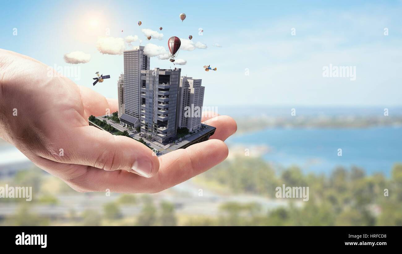 Close up of businessman hand holding construction model. Mixed media ...