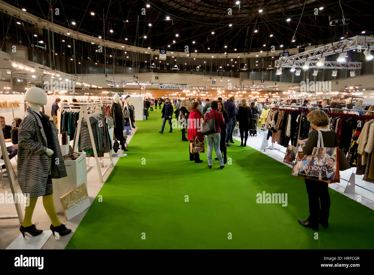 One aisle with people among fashion clothing stands in MOMAD