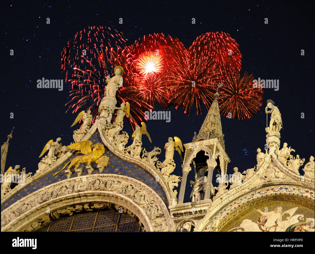 Detail of facade of Saint Mark's cathedral in Venice, Italy with Holiday fireworks exploding in the background. Stock Photo