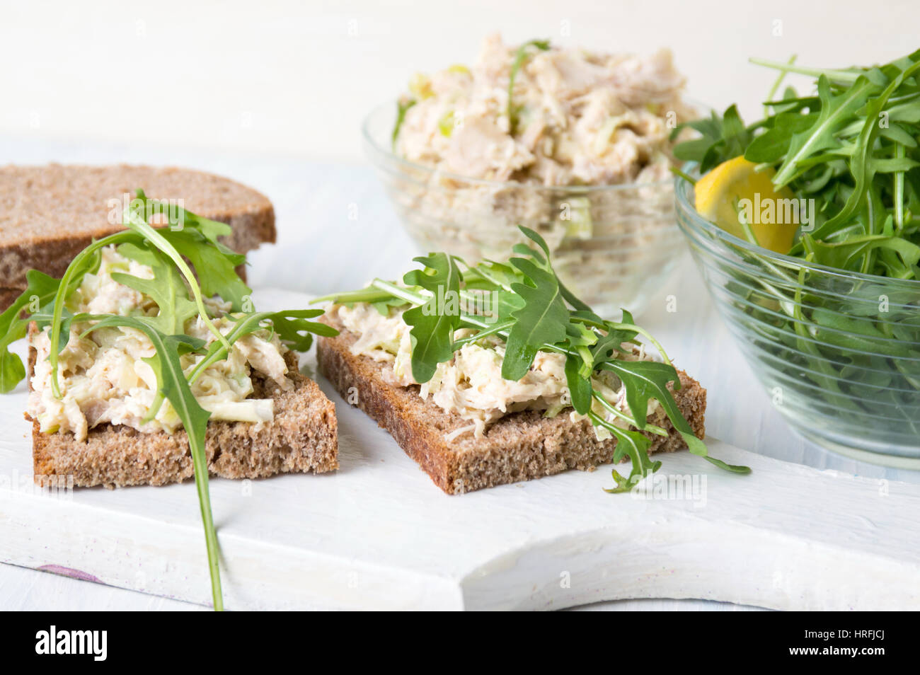 Chicken salad and arugula sandwich on wooden board Stock Photo