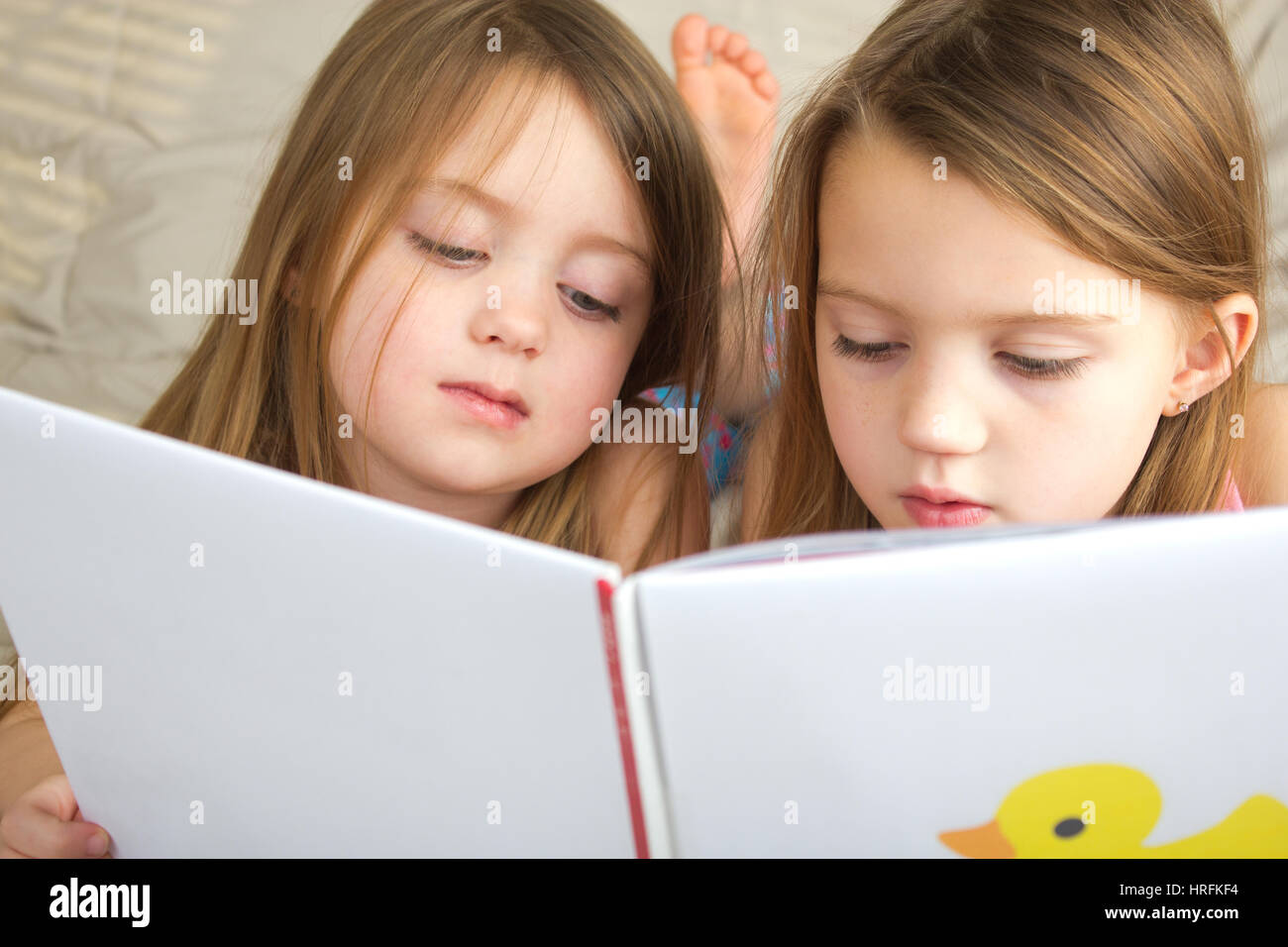 Little girls reading a story together Stock Photo