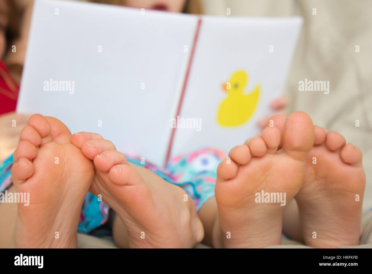 Barefoot children reading a story Stock Photo