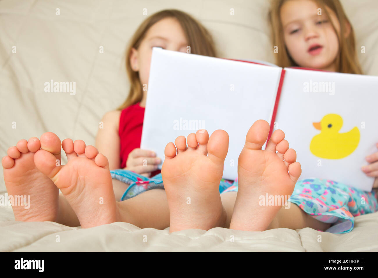 Children reading a book in bed Stock Photo
