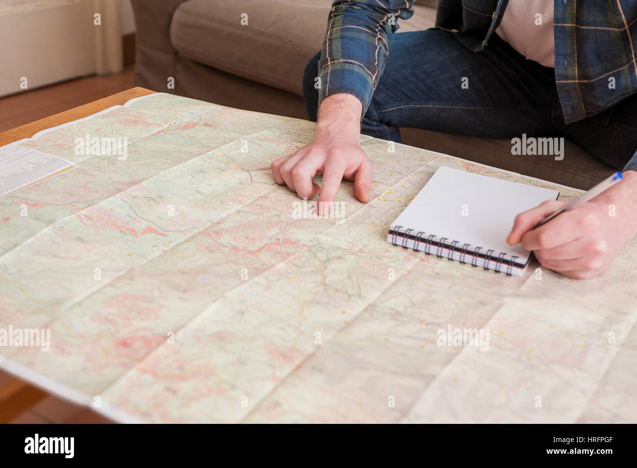 Young man at his living room with a plaid shirt and a map Stock Photo